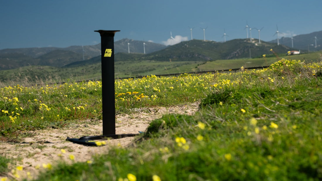 FoilHive mast in wildflowers with wind turbines in the background