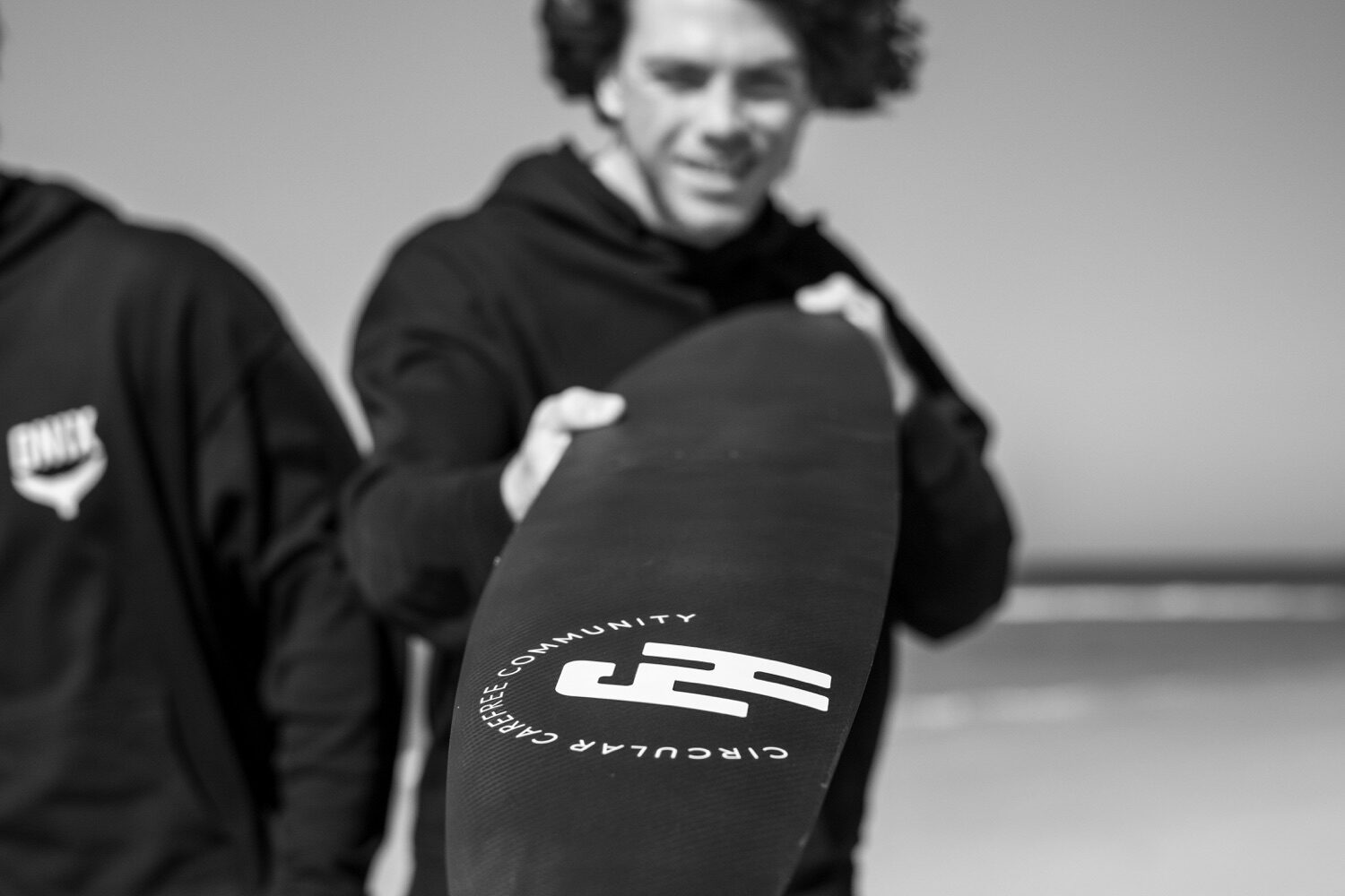 A rider smiling behind a FoilHive wing on the beach